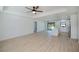 Open floor plan featuring light wood floors and white walls, with the kitchen visible in the background at 359 Salisbury St, Port Charlotte, FL 33954