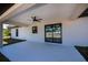 Spacious, covered patio with a ceiling fan and sliding glass doors leading to the backyard at 359 Salisbury St, Port Charlotte, FL 33954