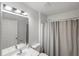 Bright bathroom featuring a shower with neutral curtain, a vanity with a mirror, and a white toilet at 3886 Cincinnati St, North Port, FL 34286
