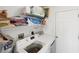 Laundry room featuring a washer and dryer, storage shelves, and ample space for laundry needs at 3886 Cincinnati St, North Port, FL 34286