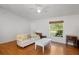 Bright living room featuring hardwood floors, a comfortable sofa, and a large window that provides scenic views at 3886 Cincinnati St, North Port, FL 34286