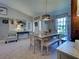 Bright dining area featuring a wooden table, comfortable seating, and a view of the entryway at 4092 Troost St, North Port, FL 34288