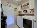 Well-organized laundry room featuring a washer, dryer, and storage shelves at 4092 Troost St, North Port, FL 34288