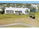 Aerial view of condos showing a large lawn with sidewalks and a nearby golf course at 410 Cerromar S Cir # 240, Venice, FL 34293
