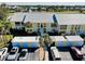 Aerial view of condos featuring white stairs, storage units and ample parking with lush grounds and a scenic pond at 410 Cerromar S Cir # 240, Venice, FL 34293