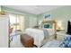Comfortable bedroom has access to the balcony, soft bedding and white furniture at 410 Cerromar S Cir # 240, Venice, FL 34293