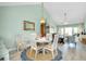 Dining area with a round table, chairs, and adjacent living room at 410 Cerromar S Cir # 240, Venice, FL 34293