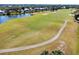 Aerial view of a meticulously manicured golf course with lush green fairways, sand traps, and a serene lake at 410 Cerromar S Cir # 240, Venice, FL 34293