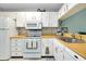 Well-lit kitchen equipped with white appliances and plentiful cabinet space at 410 Cerromar S Cir # 240, Venice, FL 34293