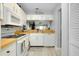 Bright kitchen with white cabinets, appliances, and view into other rooms at 410 Cerromar S Cir # 240, Venice, FL 34293