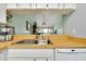Open kitchen layout with wood countertops, bar and stainless steel sink at 410 Cerromar S Cir # 240, Venice, FL 34293