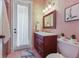 Bathroom with travertine tile, wood vanity, and access to outdoor patio at 4409 Crews Ct, Port Charlotte, FL 33952