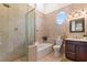 Elegant bathroom with walk-in shower, bathtub, round window, and classic vanity at 4409 Crews Ct, Port Charlotte, FL 33952