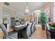 Bright dining area with travertine tile, architectural columns, and modern chandelier at 4409 Crews Ct, Port Charlotte, FL 33952