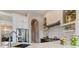 Bright kitchen featuring stainless steel appliances, white cabinetry, and a marble-topped island with a modern faucet at 4409 Crews Ct, Port Charlotte, FL 33952