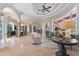Open-concept living area with travertine flooring, arched entryways, and a tray ceiling at 4409 Crews Ct, Port Charlotte, FL 33952