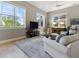 Bright living room with large windows, comfortable seating, and an adjacent screened-in lanai view at 4409 Crews Ct, Port Charlotte, FL 33952