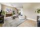 Sun-filled living room with plush seating, neutral decor, and an open layout leading to the kitchen at 4409 Crews Ct, Port Charlotte, FL 33952