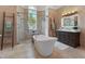 A stand alone tub, dual sinks, and glass shower make this tiled main bathroom a beautiful space at 4409 Crews Ct, Port Charlotte, FL 33952