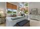 The main bedroom boasts large windows, stylish décor, a white comforter, and wood furnishings at 4409 Crews Ct, Port Charlotte, FL 33952