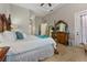 This main bedroom has a white comforter, detailed wooden bedframe, and is adjacent to the main bathroom at 4409 Crews Ct, Port Charlotte, FL 33952