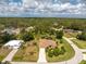 Aerial view of a single story home with a well-manicured lawn, mature trees, and a long driveway at 4443 Abcor Rd, North Port, FL 34286