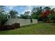 Spacious backyard with a manicured lawn, privacy fence, and lush landscaping at 4443 Abcor Rd, North Port, FL 34286