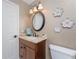 Bathroom with vanity sink, granite countertop, framed mirror, and decorative wall flowers at 4443 Abcor Rd, North Port, FL 34286