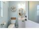 Powder room featuring a decorative sea shell wreath above the toilet, and round mirror over the vanity at 4443 Abcor Rd, North Port, FL 34286