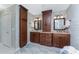 Bathroom boasting dual sinks, dark wood cabinets, and stylish floral wallpaper at 4443 Abcor Rd, North Port, FL 34286