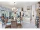 Cozy dining area with round glass table, wicker chairs, chandelier, and view into kitchen at 4443 Abcor Rd, North Port, FL 34286