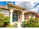 Close up front view of a tan stucco home featuring a charming front door with decorative wreath at 4443 Abcor Rd, North Port, FL 34286