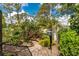 Landscaped garden features stone walkway, bird feeder, and a variety of plants at 4443 Abcor Rd, North Port, FL 34286
