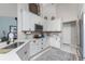 Well-lit kitchen featuring white cabinetry, stainless steel appliances, and a view into the living room at 4443 Abcor Rd, North Port, FL 34286