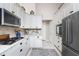 Bright kitchen featuring white cabinets, granite countertops, stainless steel appliances, and decorative backsplash at 4443 Abcor Rd, North Port, FL 34286