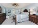 Bright main bedroom featuring a large bed, sitting area, and dark wood furniture at 4443 Abcor Rd, North Port, FL 34286