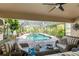 Relaxing covered patio area overlooking the screened-in pool and lush backyard oasis at 4443 Abcor Rd, North Port, FL 34286