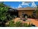 Paver patio with a fire pit, seating, potted plants, and views of a screened pool and the backyard at 4443 Abcor Rd, North Port, FL 34286