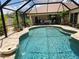 Inviting screened-in pool with waterfall feature and ample patio space, perfect for outdoor entertaining at 4443 Abcor Rd, North Port, FL 34286