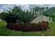 Well-manicured yard with a colorful flower garden, trimmed bushes, and a privacy fence at 4443 Abcor Rd, North Port, FL 34286