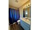 Cozy bathroom featuring blue shower curtain, vanity with mirror and sink, and tile floors at 5498 Montego Ln, Port Charlotte, FL 33981