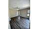 Spacious bedroom featuring wood floors, neutral walls, ceiling fan, and multiple windows for ample natural light at 5498 Montego Ln, Port Charlotte, FL 33981
