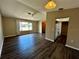 Open living room with hardwood floors, ceiling fan, large window and view to kitchen at 5498 Montego Ln, Port Charlotte, FL 33981