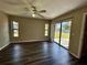 Inviting living room with natural light, wood flooring, ceiling fan and a sliding glass door to the outside at 5498 Montego Ln, Port Charlotte, FL 33981
