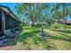 Lush green backyard with mature trees offering ample shade and privacy at 5641 Mashie Cir, North Port, FL 34287