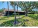 The property features a well-maintained lawn, mature trees, and an enclosed patio at 5641 Mashie Cir, North Port, FL 34287