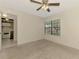 Cozy bedroom view highlighting neutral carpet, a window, and a glimpse into the adjacent kitchen area at 5641 Mashie Cir, North Port, FL 34287