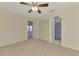 Bedroom featuring neutral carpet, a ceiling fan, and an open doorway to other parts of the house at 5641 Mashie Cir, North Port, FL 34287
