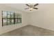 Bedroom featuring neutral carpet and a ceiling fan, complemented by natural light from a window at 5641 Mashie Cir, North Port, FL 34287