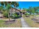 Charming home exterior with lush tropical landscaping and mature trees in a sunny setting at 5641 Mashie Cir, North Port, FL 34287